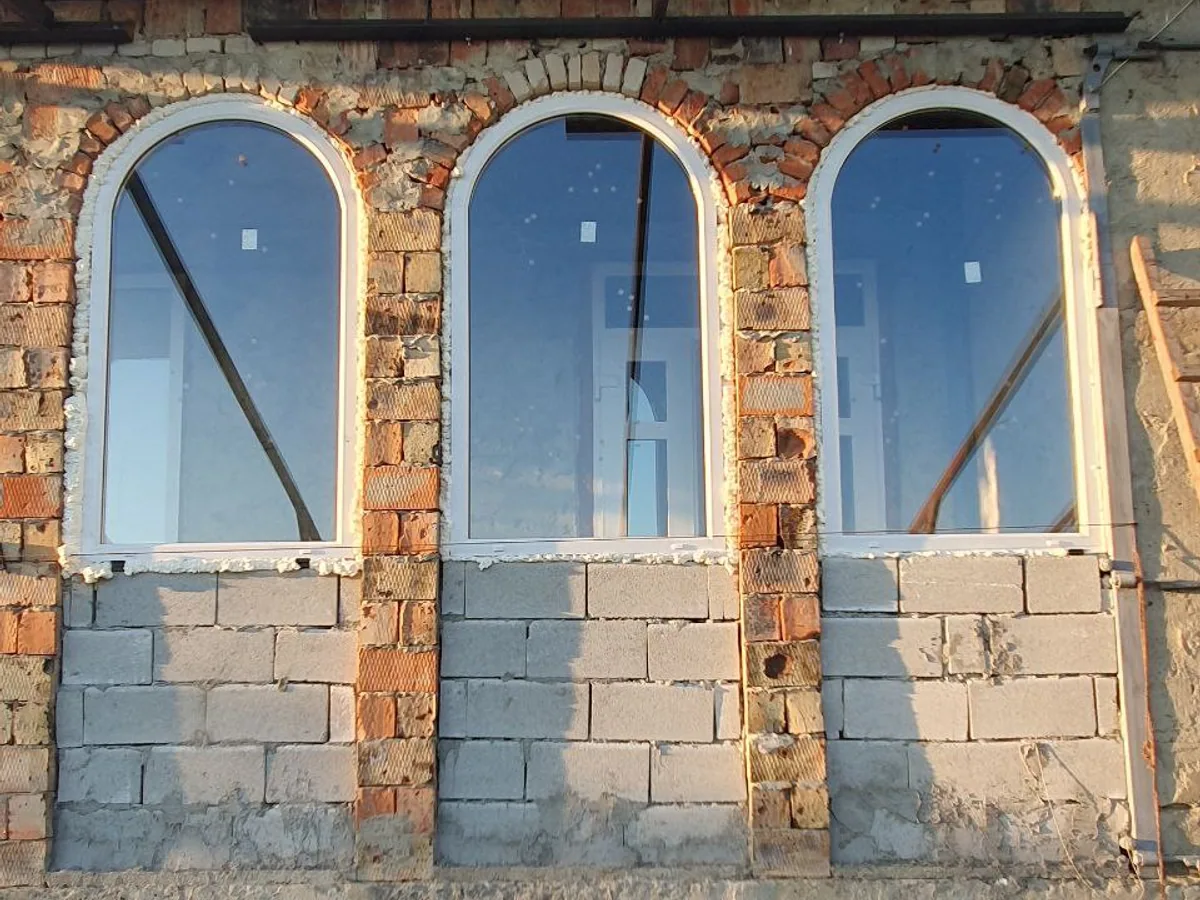 Trei ferestre termopan arcuite cu profil PVC alb în zidărie mixtă