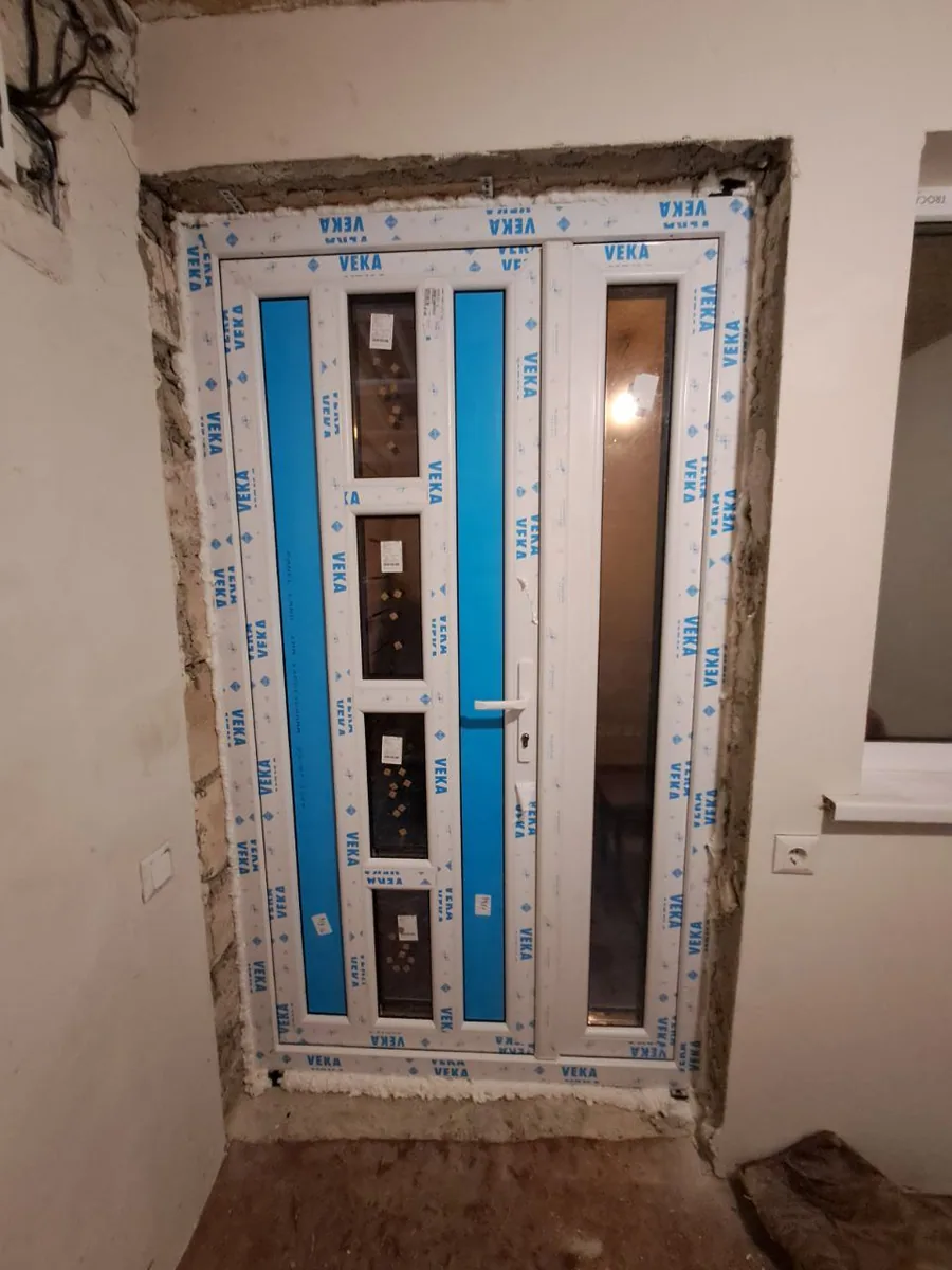 Ușă PVC albă cu patru geamuri mici centrale și panou lateral vitrat